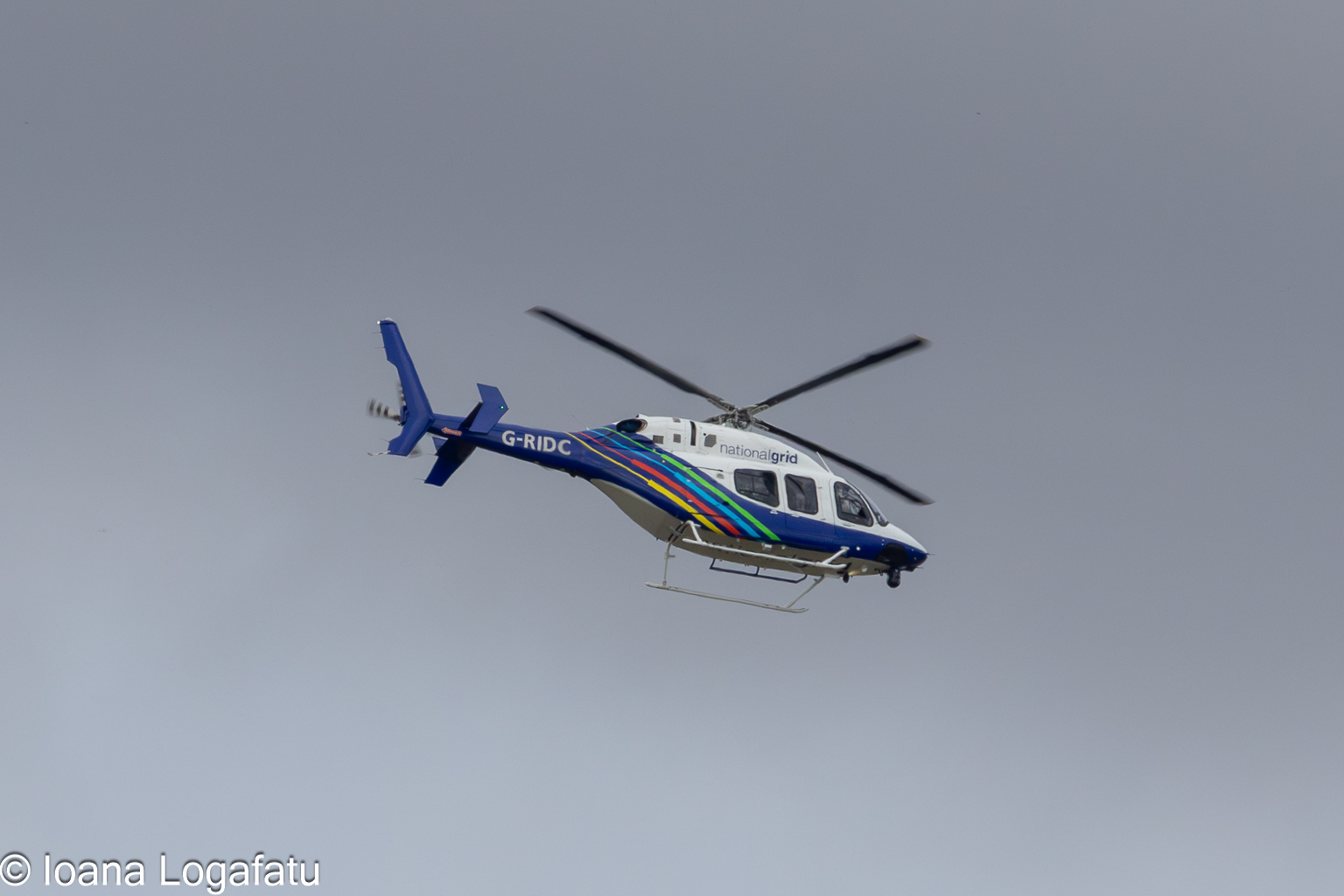 Helicopter flying overcast skies above land